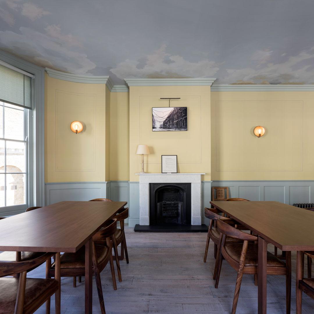 Elegant meeting space in The Sekforde with wooden tables and cozy fireplace. - Banner