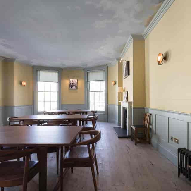 Elegant meeting room with wooden tables, ideal for workshops and intimate gatherings.