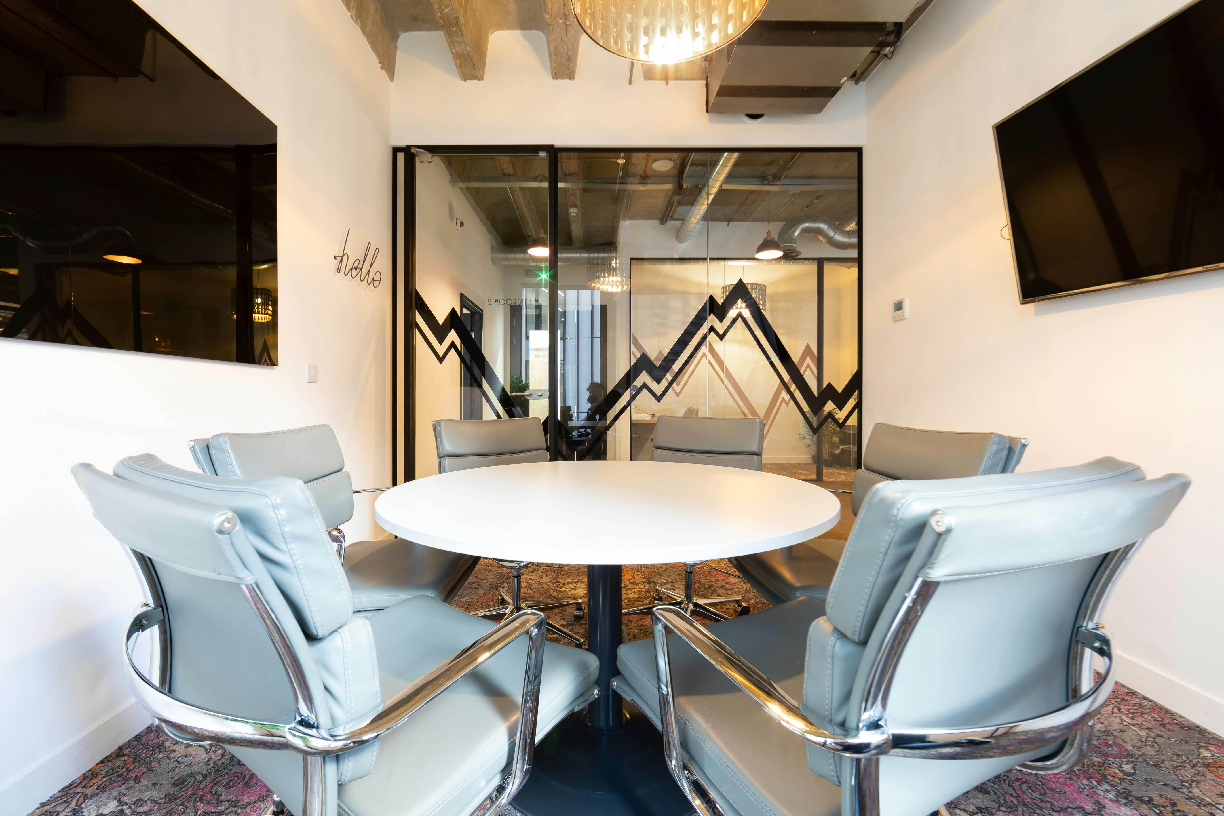 Modern meeting room with round table for collaborative brainstorming sessions at The Space Aldgate.