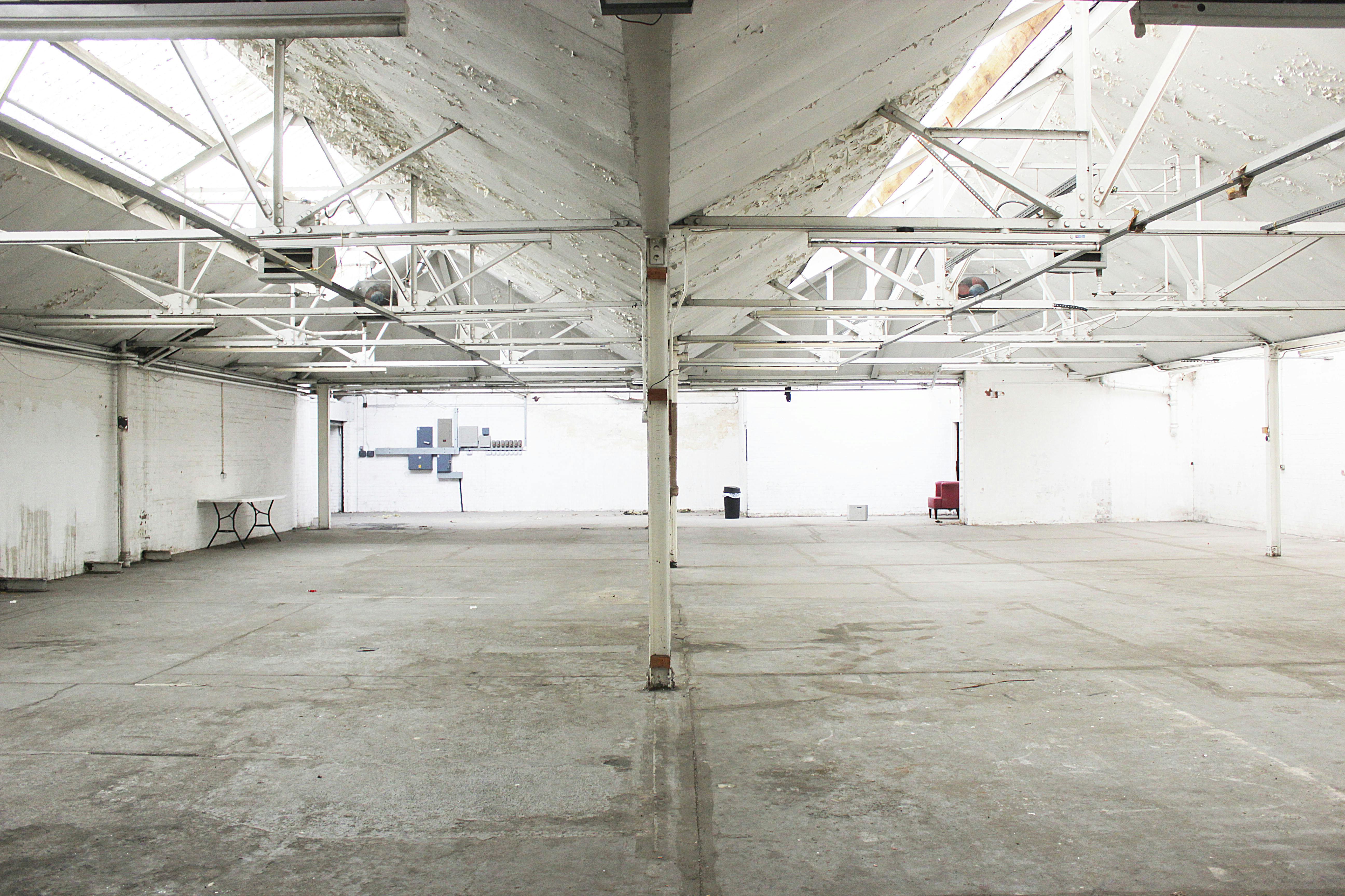 Spacious industrial venue with high ceilings for corporate events and workshops.