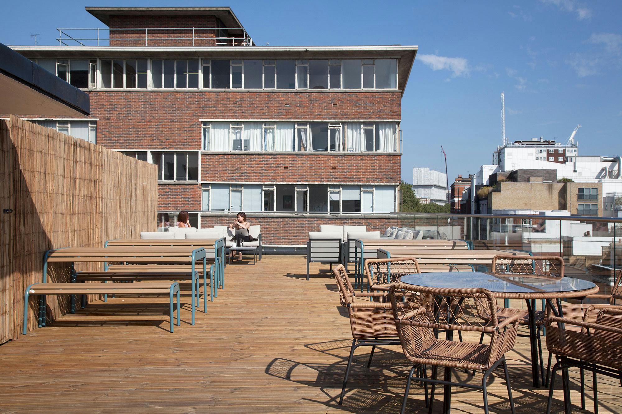 Spacious rooftop venue with wooden deck for outdoor meetings and summer events.