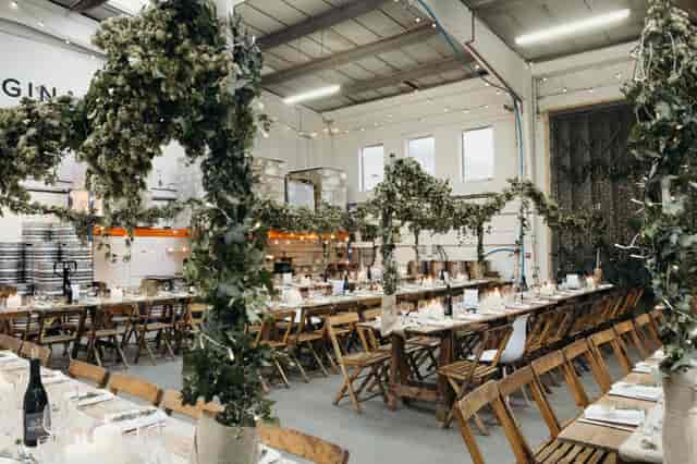 Main Brew Room at Small Beer Brewery, elegant dinner setup in lush greenery for events.