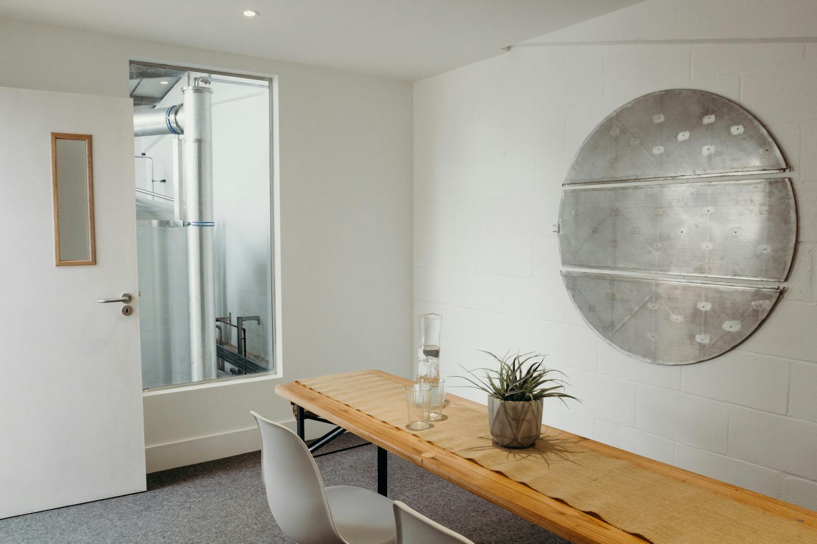 Minimalist meeting room at Small Beer Brewery with wooden table, ideal for brainstorming sessions.