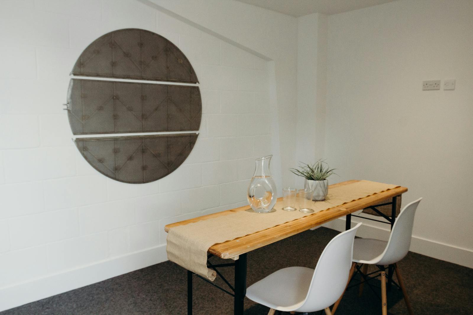 Minimalist meeting room with wooden table at Small Beer Brewery for intimate discussions.