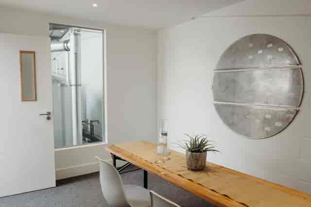 Minimalist meeting room with wooden table at Small Beer Brewery for team brainstorming.