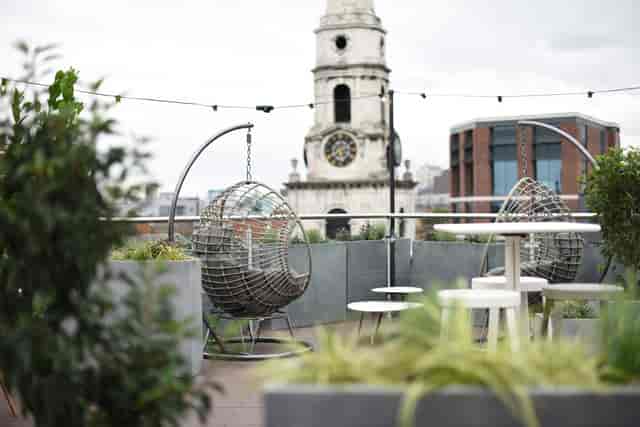 Stylish rooftop venue with hanging chairs, ideal for cocktail receptions and networking events.