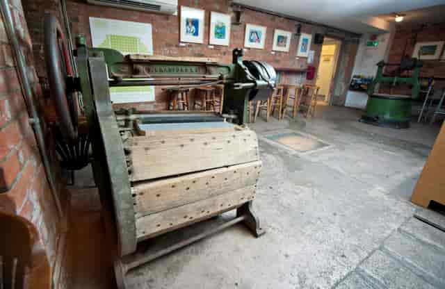 Vintage printing press in rustic Theatre Bar, perfect for creative workshops and events.