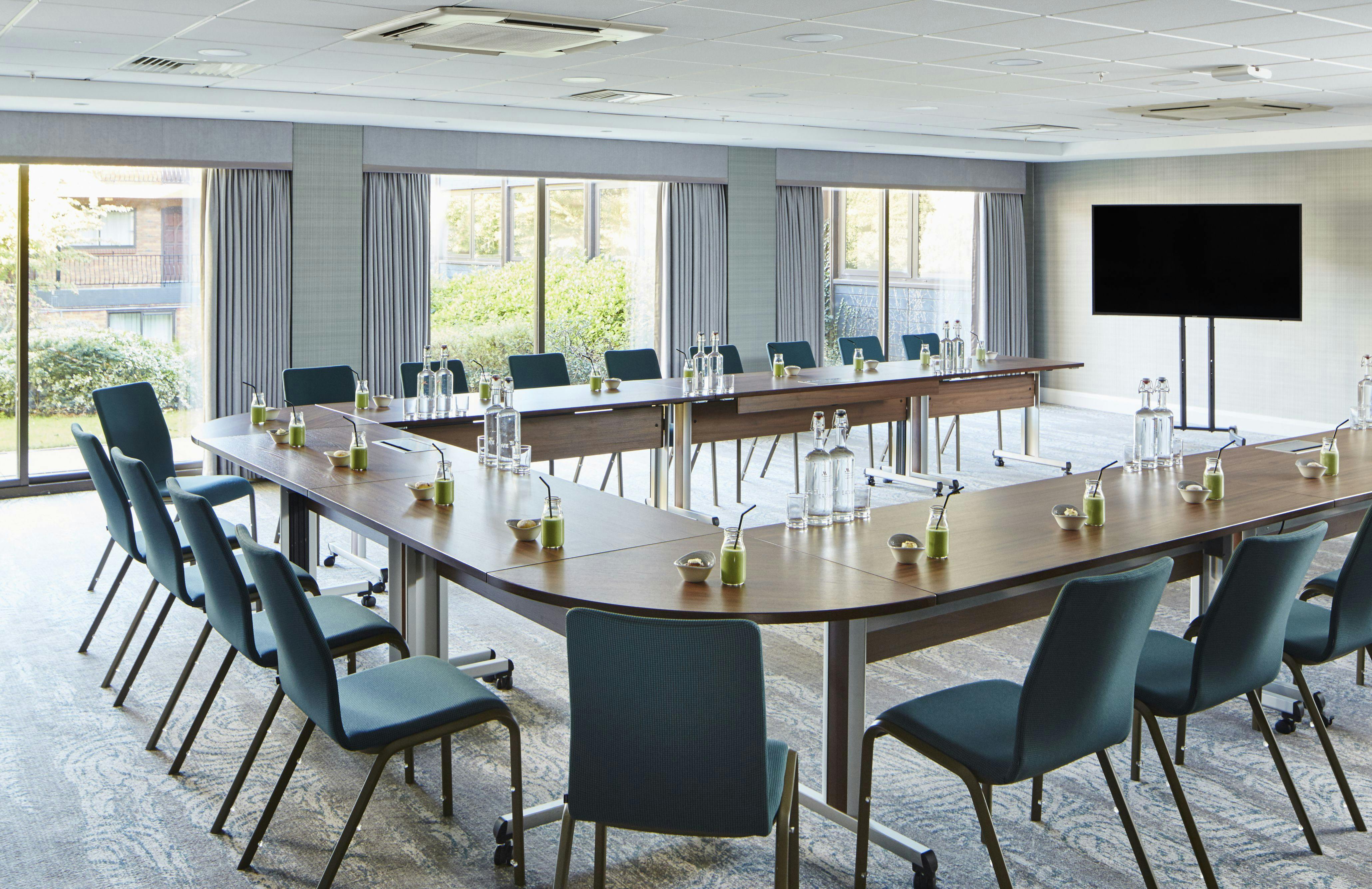 Modern meeting room at Delta Hotels Manchester with U-shaped table for professional events.