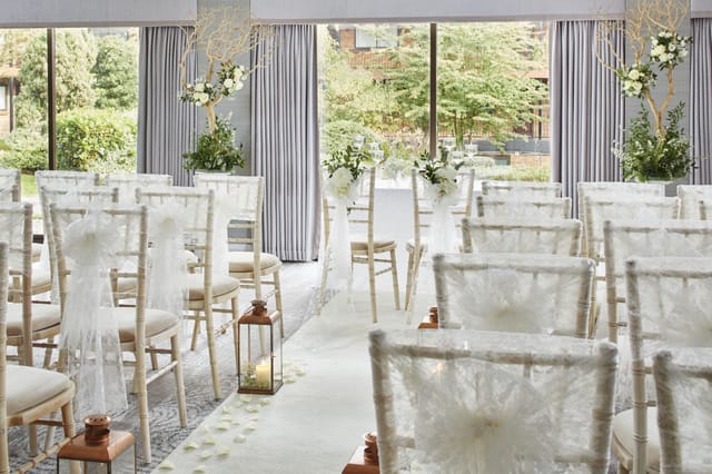 Elegant wedding venue with white chairs and floral accents at Delta Hotels Manchester.