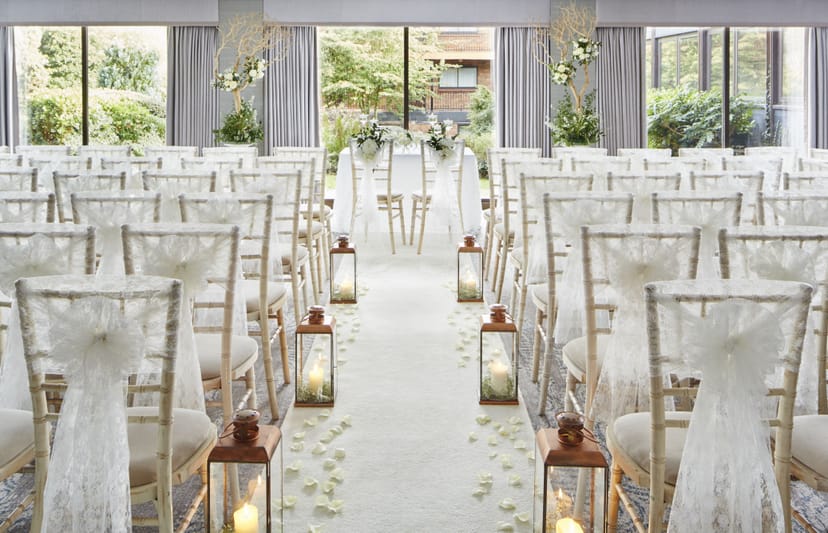 Rosewood Room at Delta Hotels: elegant wedding ceremony space with white chairs and lanterns.