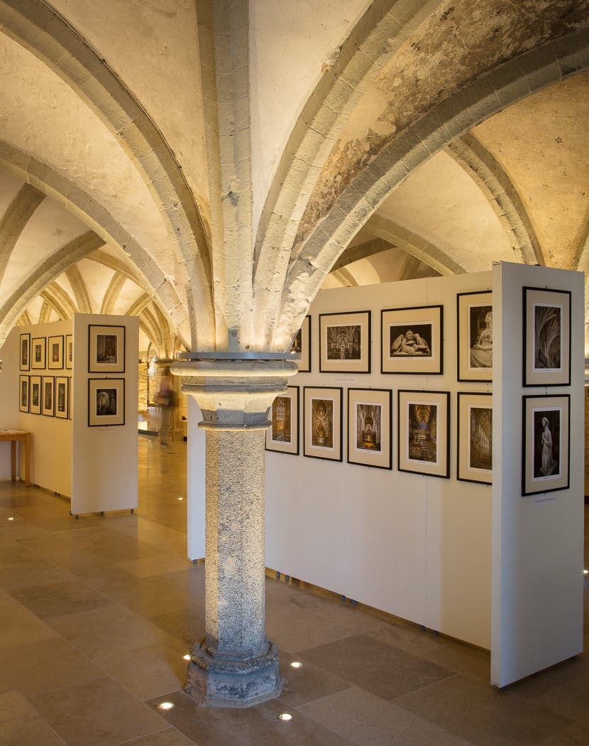Crypt in Rochester Cathedral with framed photos, ideal for art exhibitions and events.