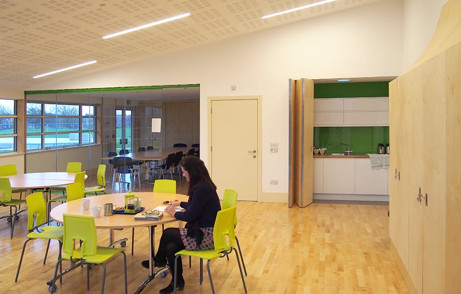 Modern meeting space in Gamlingay Eco Hub with vibrant green chairs, perfect for workshops.