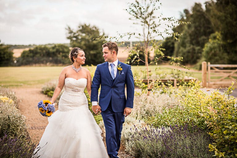 Couple walking hand in hand at Gamlingay Eco Hub, perfect for romantic weddings.