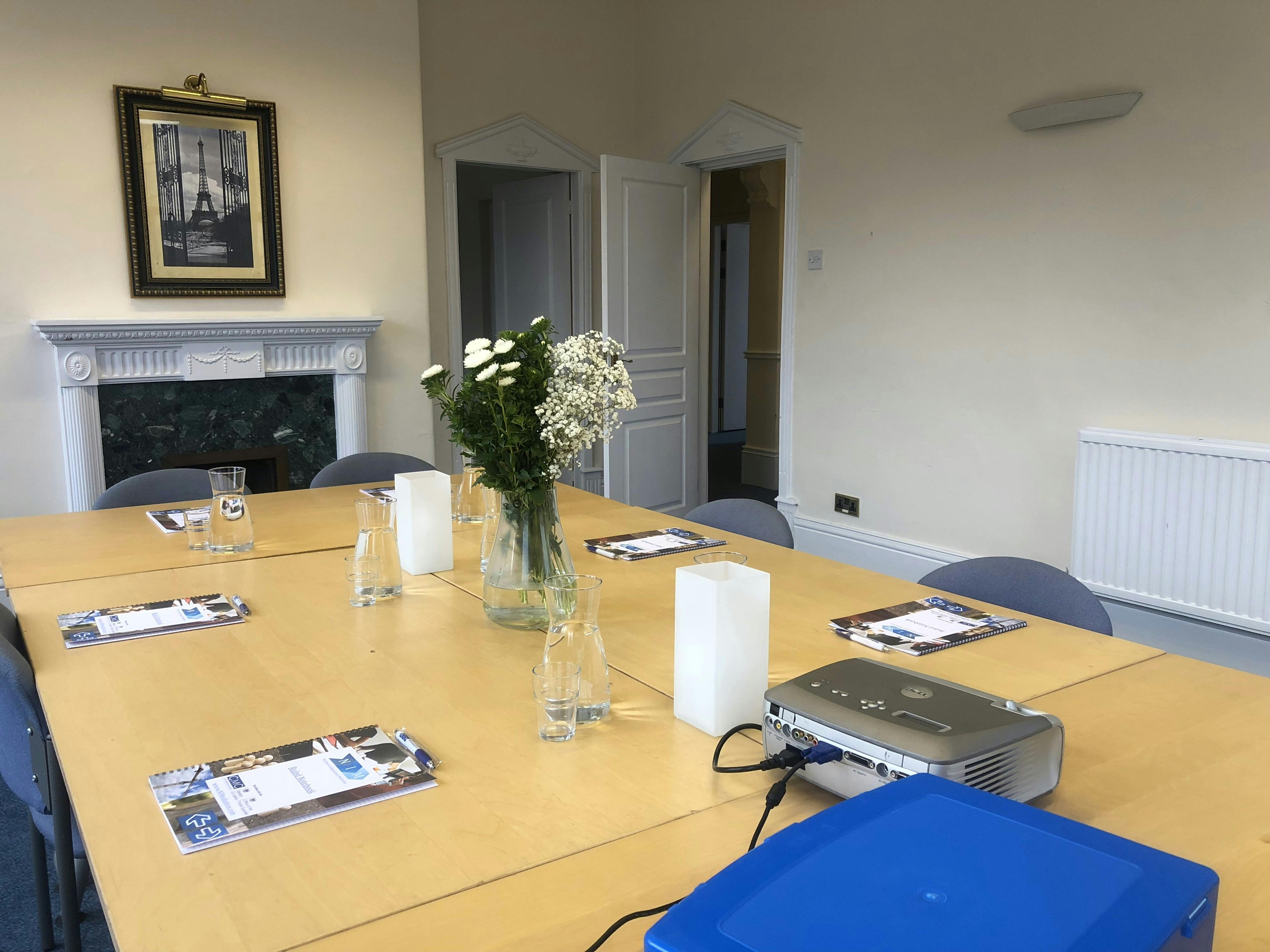 Whernside Boardroom with organized table, projector, and fresh flowers for meetings.