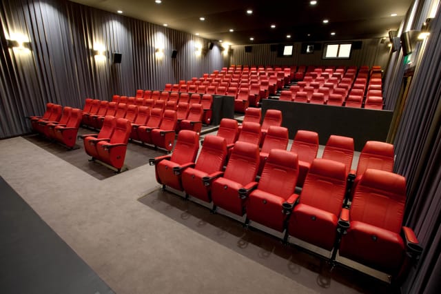 Modern auditorium with red seating at Barbican Centre for corporate events and film screenings.