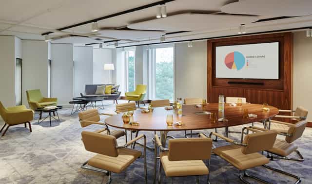Modern meeting room at London Heathrow Marriott with circular table for collaboration.