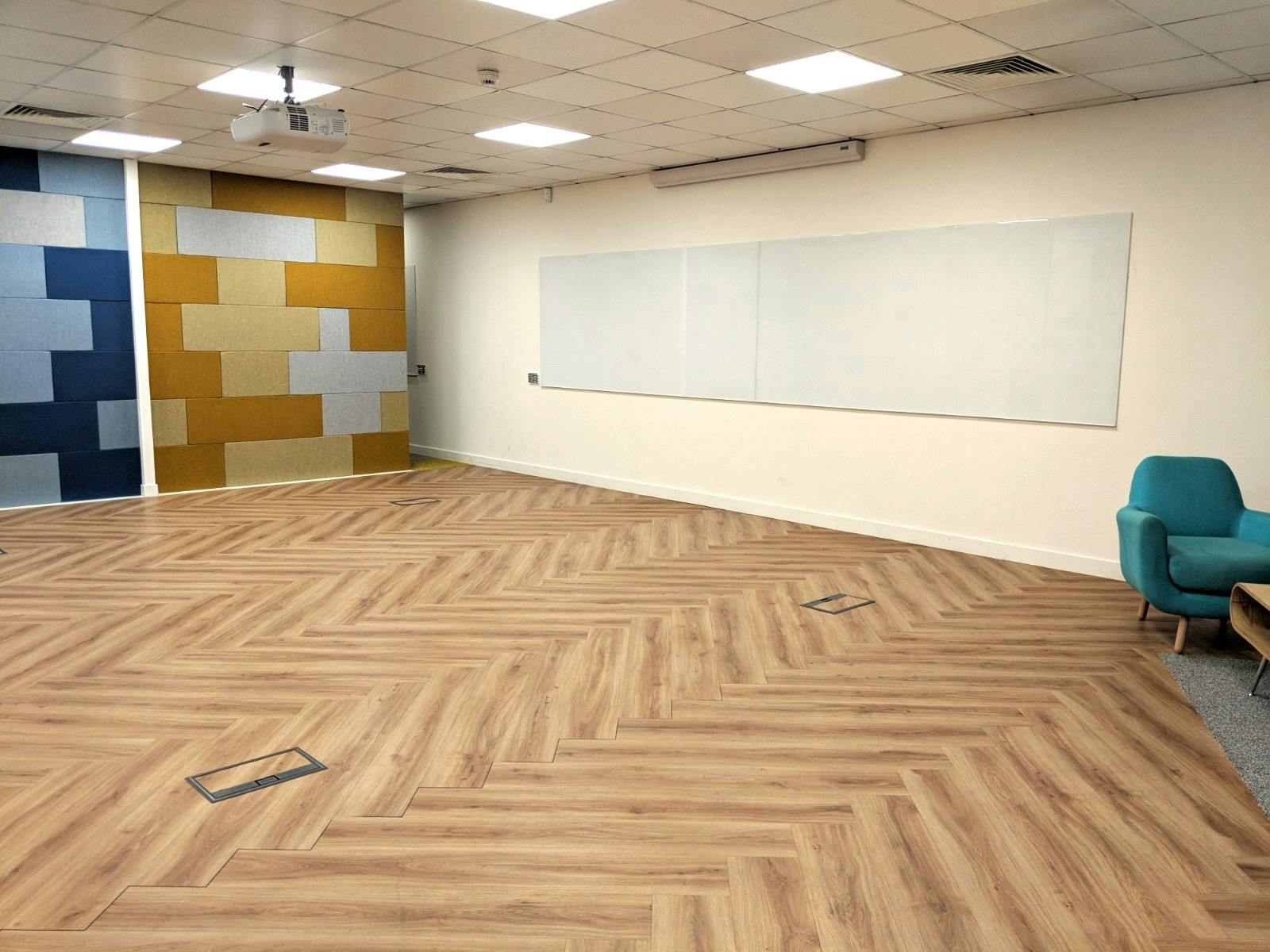 Modern workshop space with herringbone flooring, ideal for collaborative sessions.