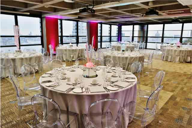 Elegant London Rooms event space with round tables and modern acrylic chairs. Perfect for weddings.