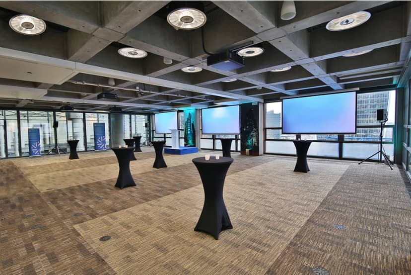 Modern event space in The London Rooms, featuring sleek black cocktail tables and city views.