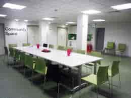 Community room with lime-green chairs for workshops and collaborative meetings.