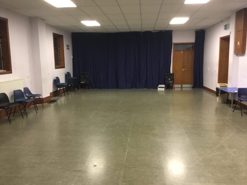 Spacious meeting room with blue curtains, ideal for workshops and presentations.