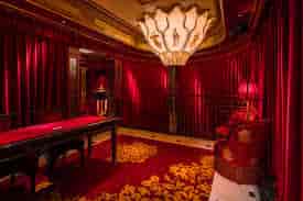 Elegant meeting space at Club Chinois with red drapery, ideal for high-end events.