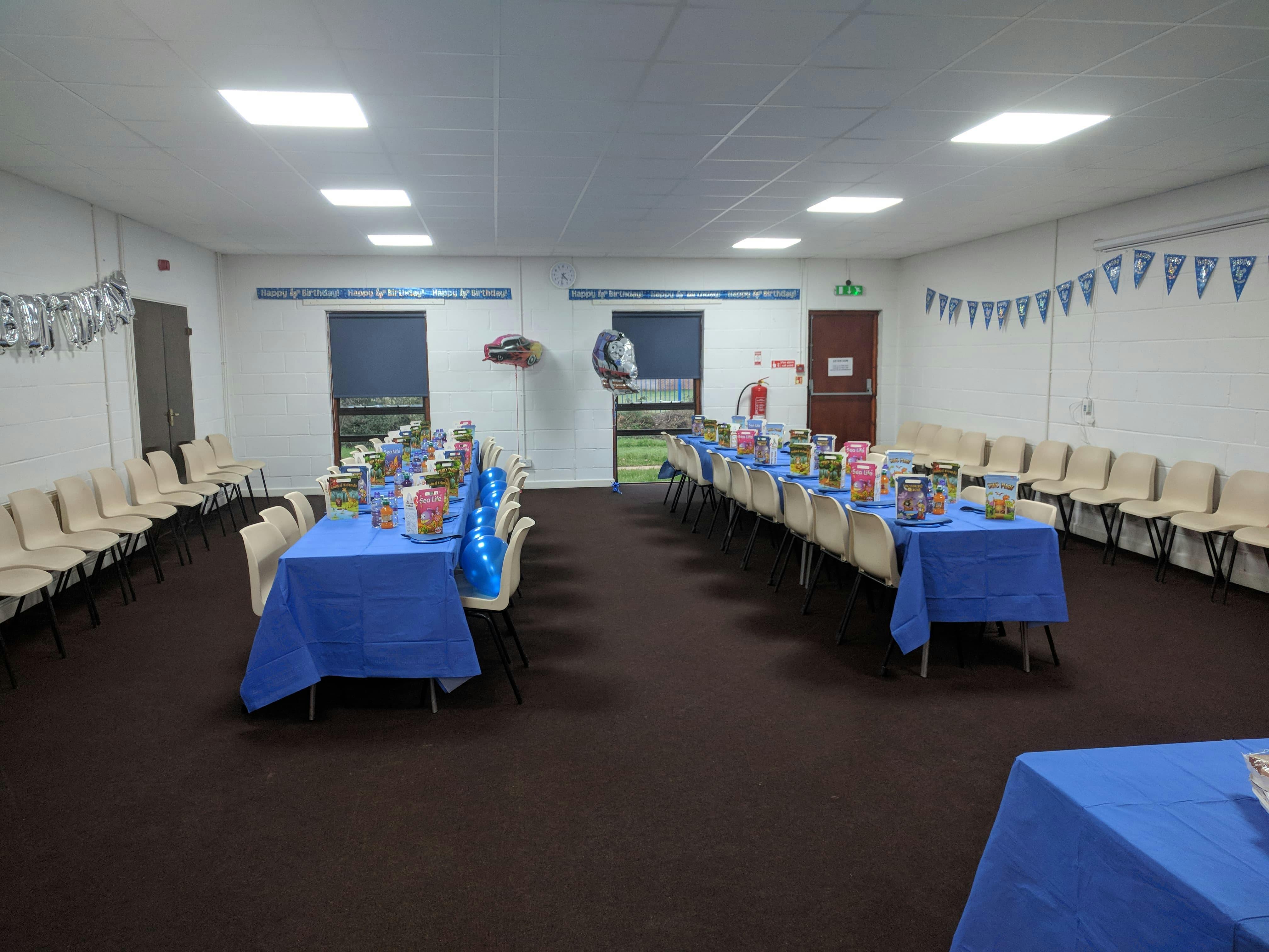 Houghton Room event space with blue-draped tables for gatherings and celebrations.