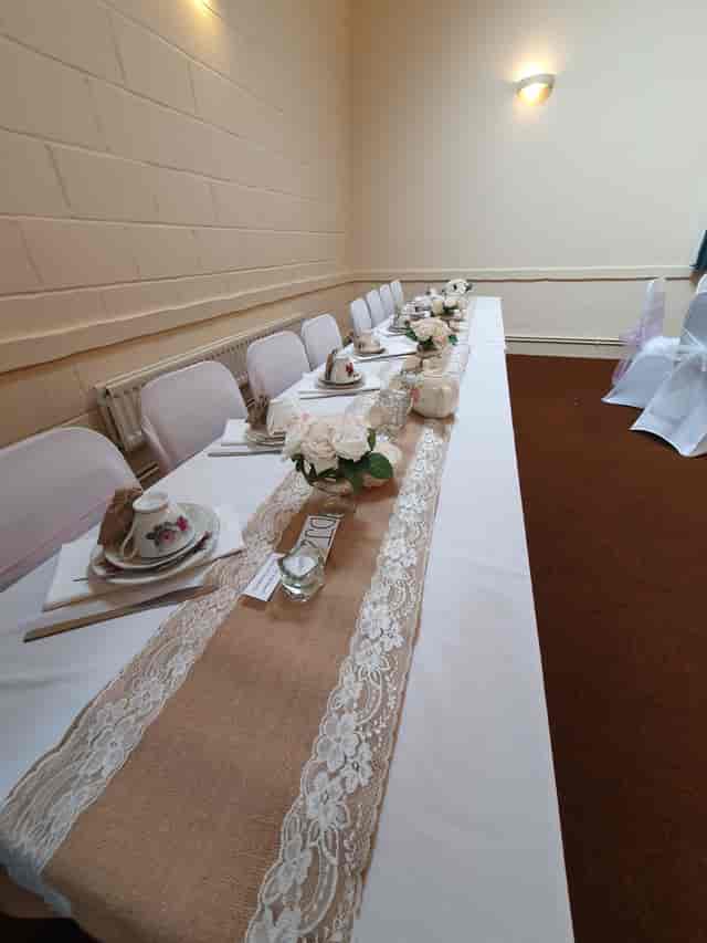Elegant table setting with floral centerpieces at Wickham Community Centre event.