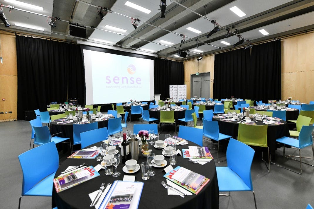 Elegant conference setup with round tables and multimedia screen at TouchBase Pears.