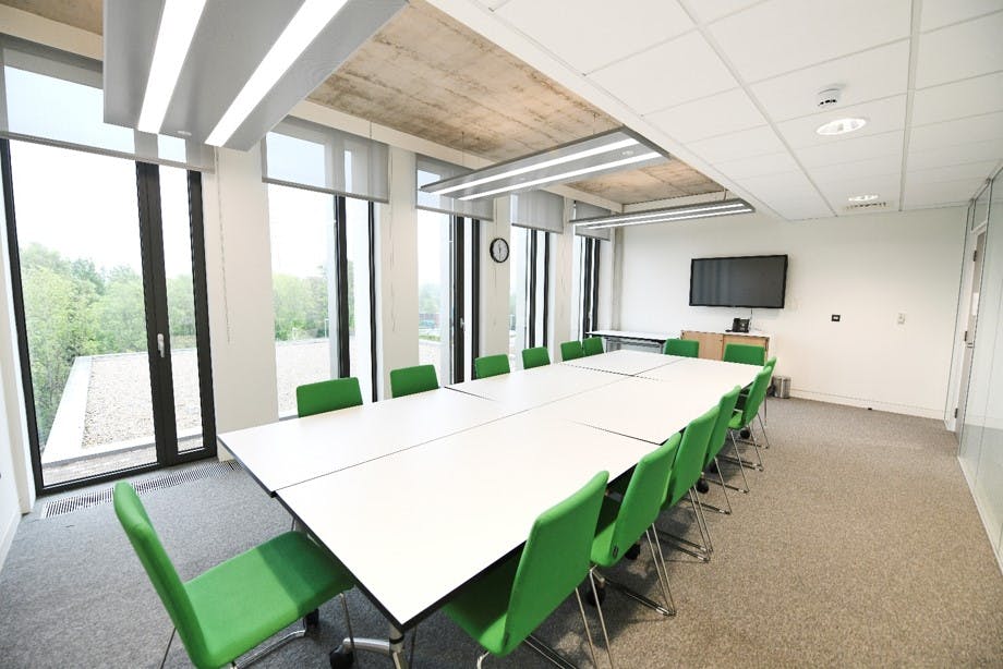 Modern meeting room with ergonomic green chairs for collaborative sessions at TouchBase Pears.