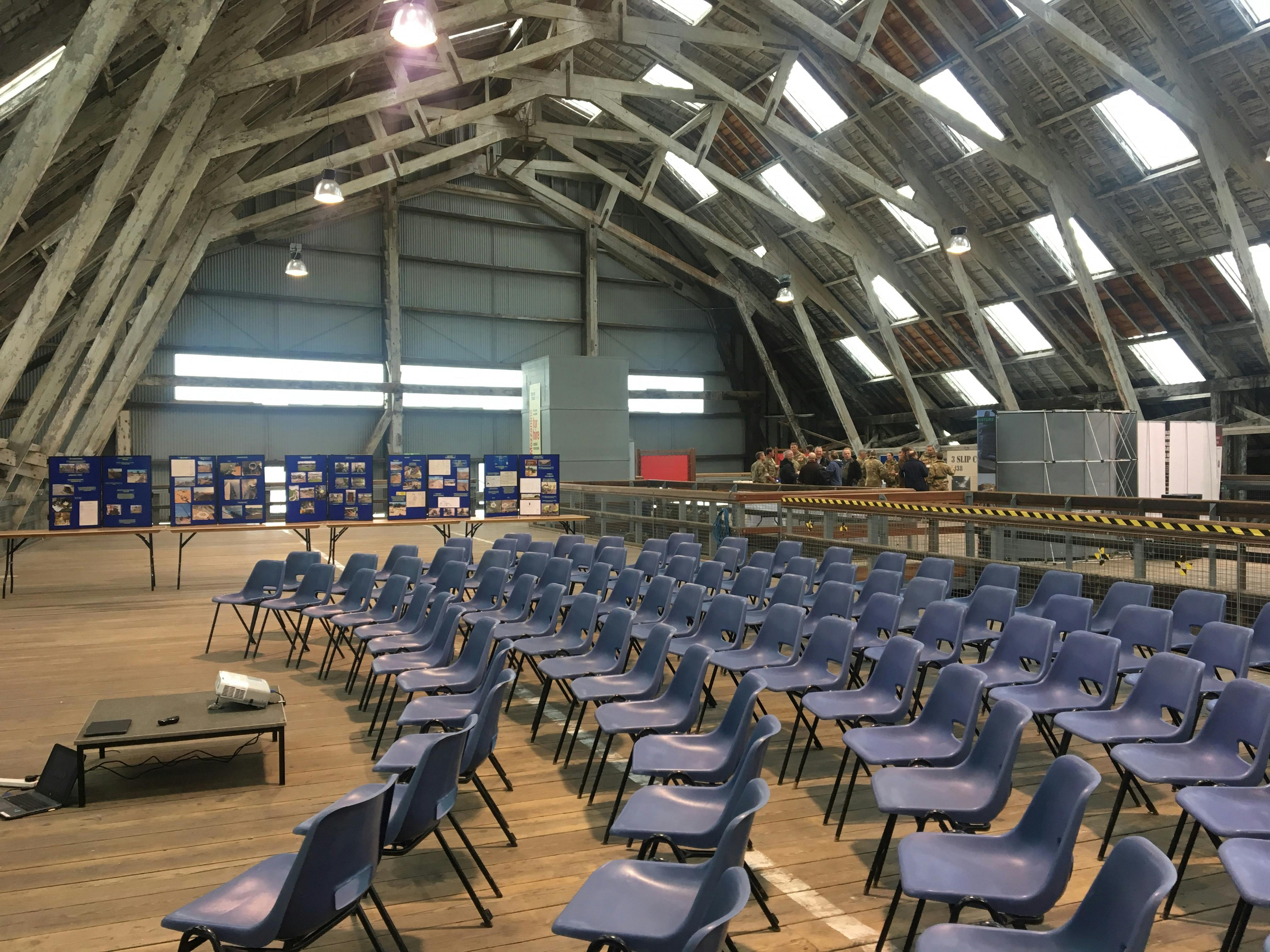 Spacious Slip Mezzanine venue with blue chairs for conferences and workshops.