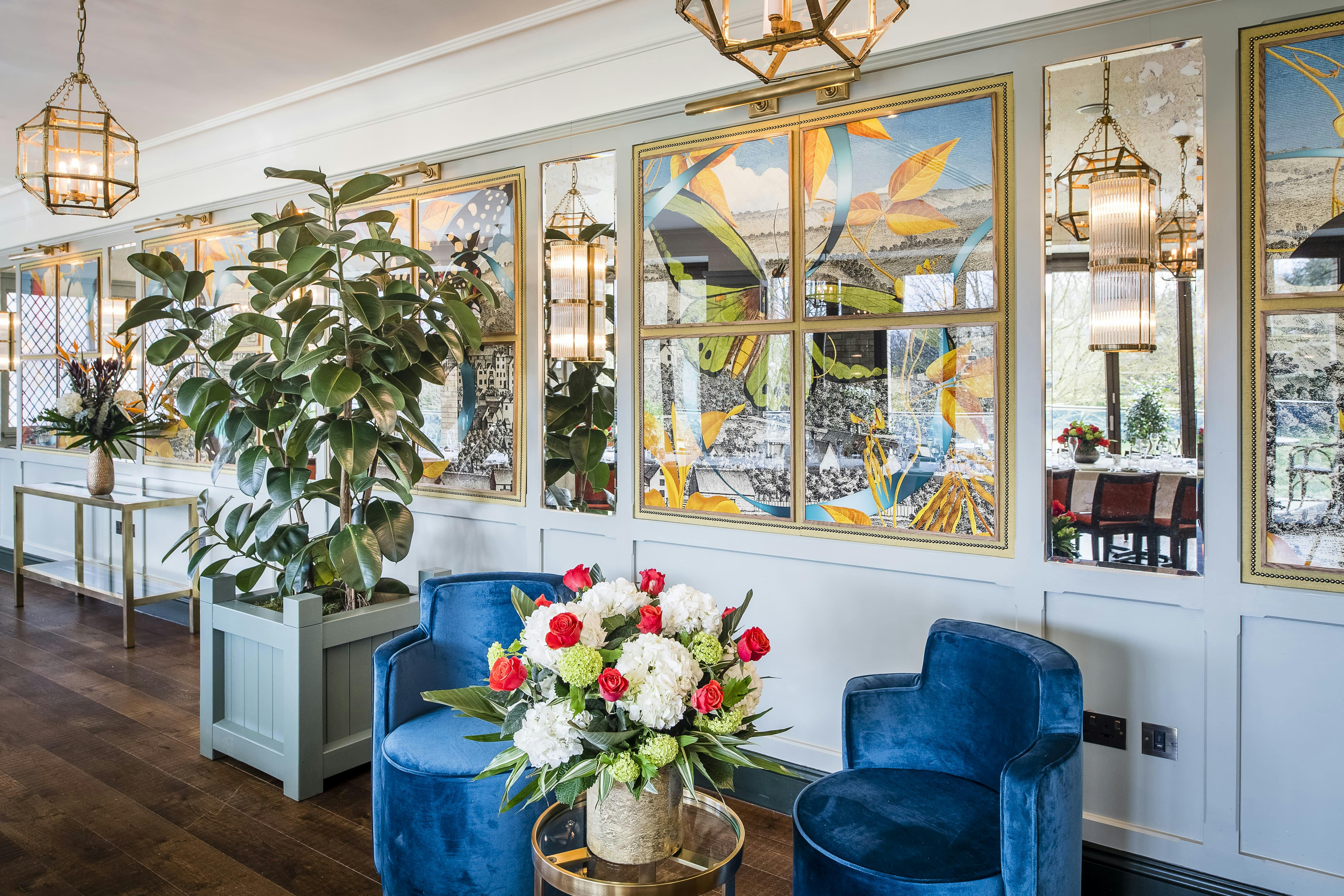 Elegant event space with plush blue chairs and floral decor in Guildford.