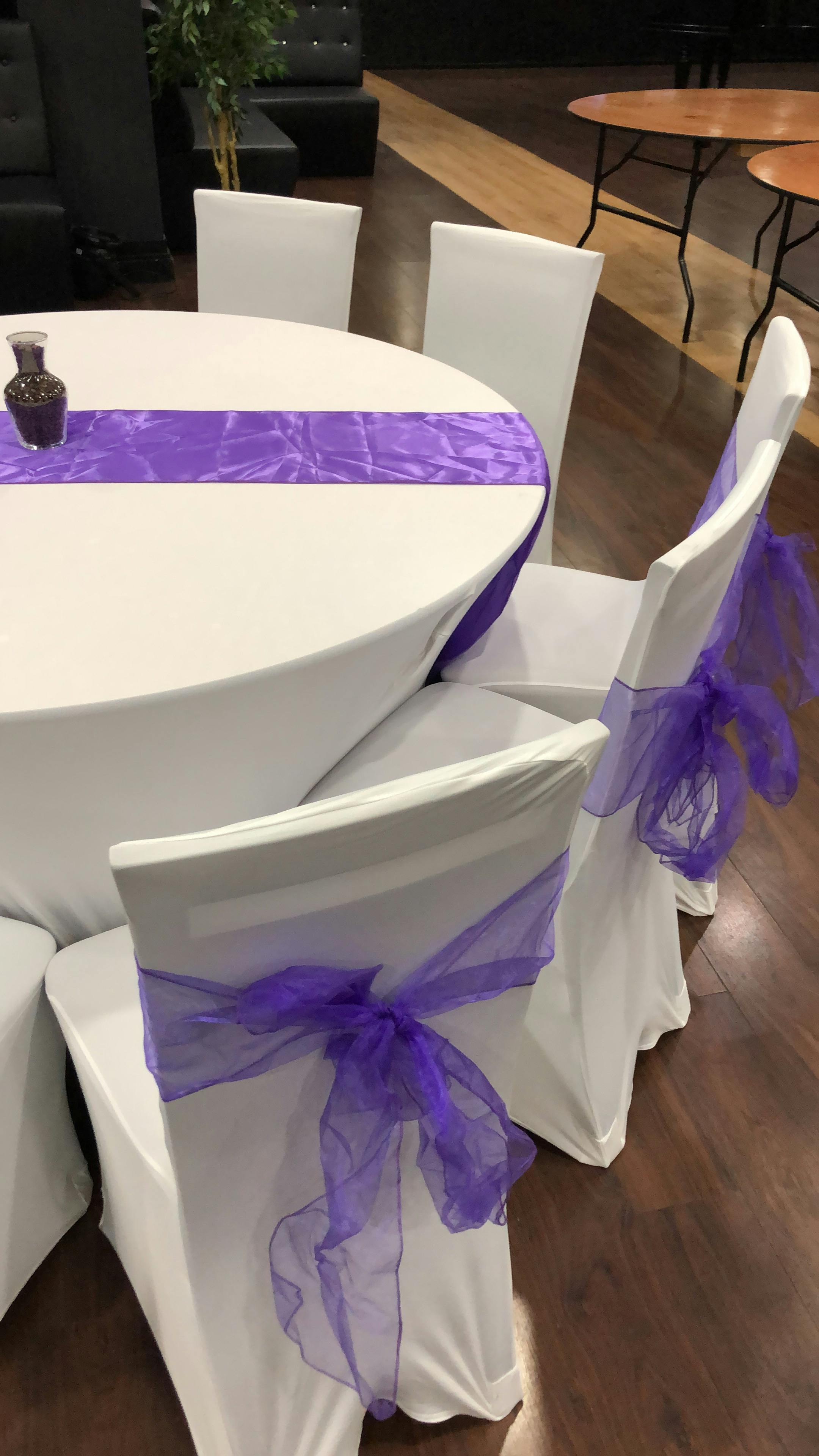 Elegant table setting with purple tulle sashes for weddings and formal events in Hagefen.