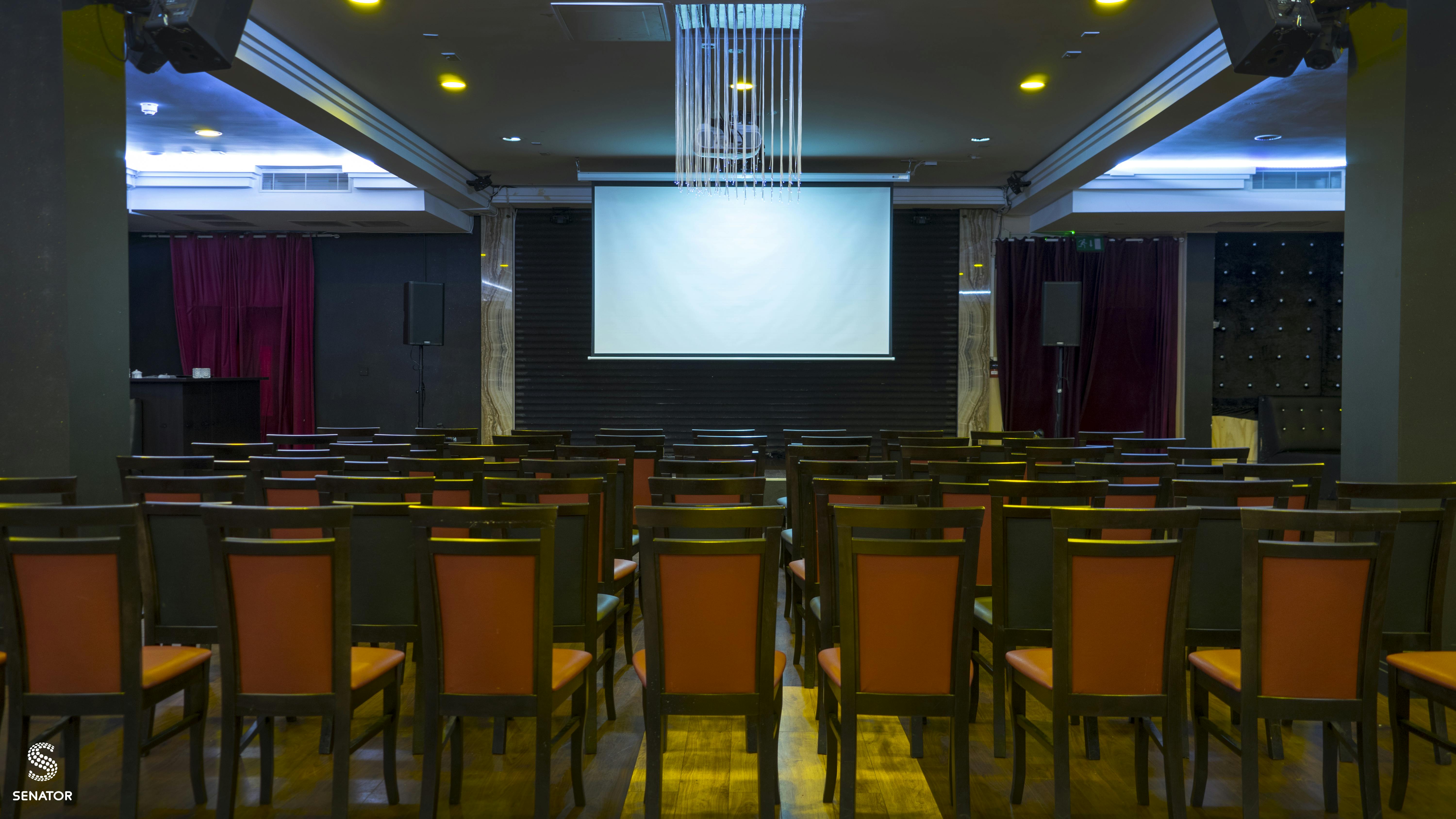 Elegant event space with chairs and screen for conferences in Hagefen.