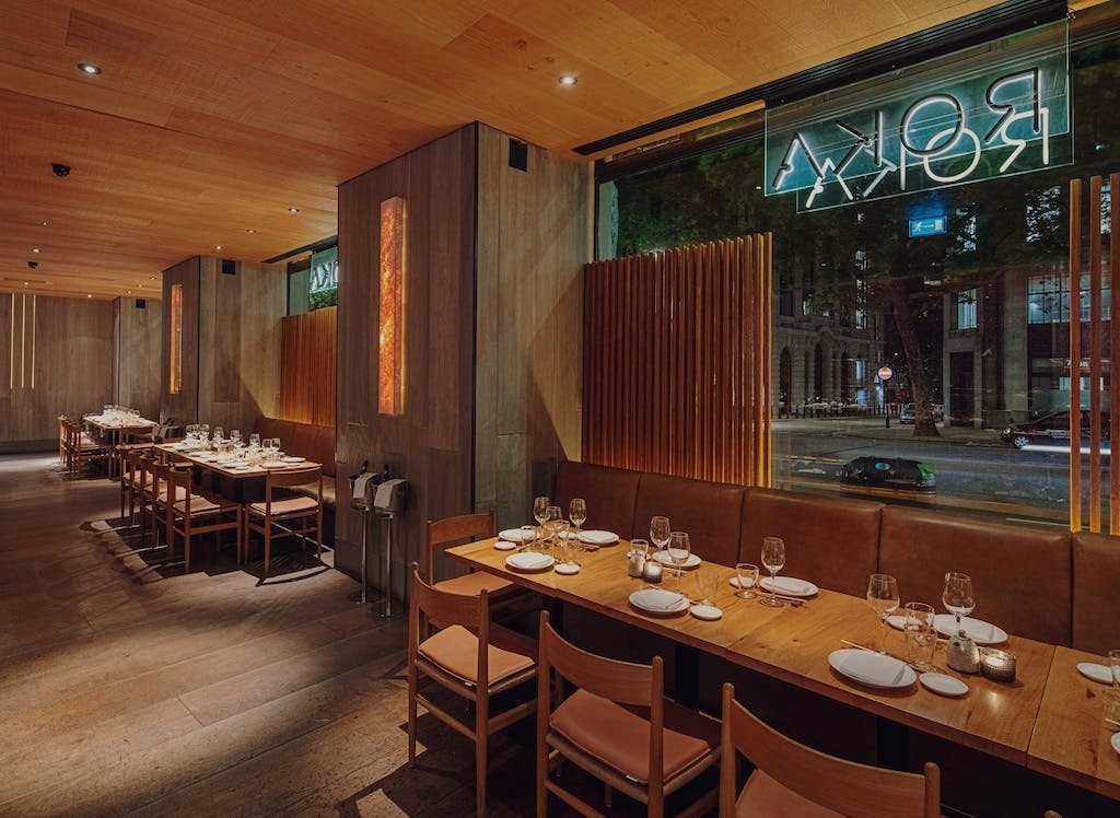 Modern lounge bar at ROKA Aldwych, featuring warm wood tones for corporate dinners.