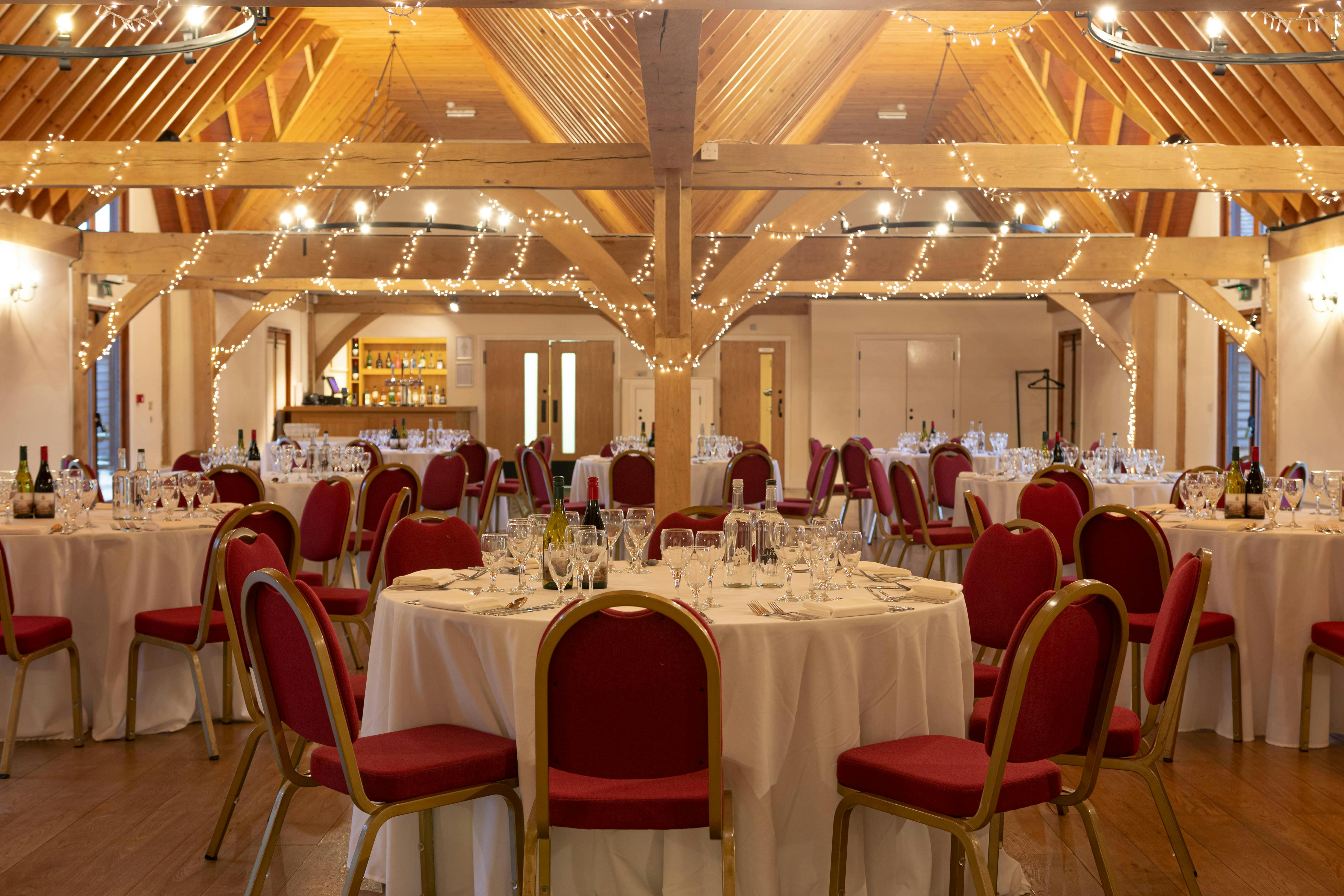 Cobbold Barn event space with round tables, ideal for weddings and corporate gatherings.