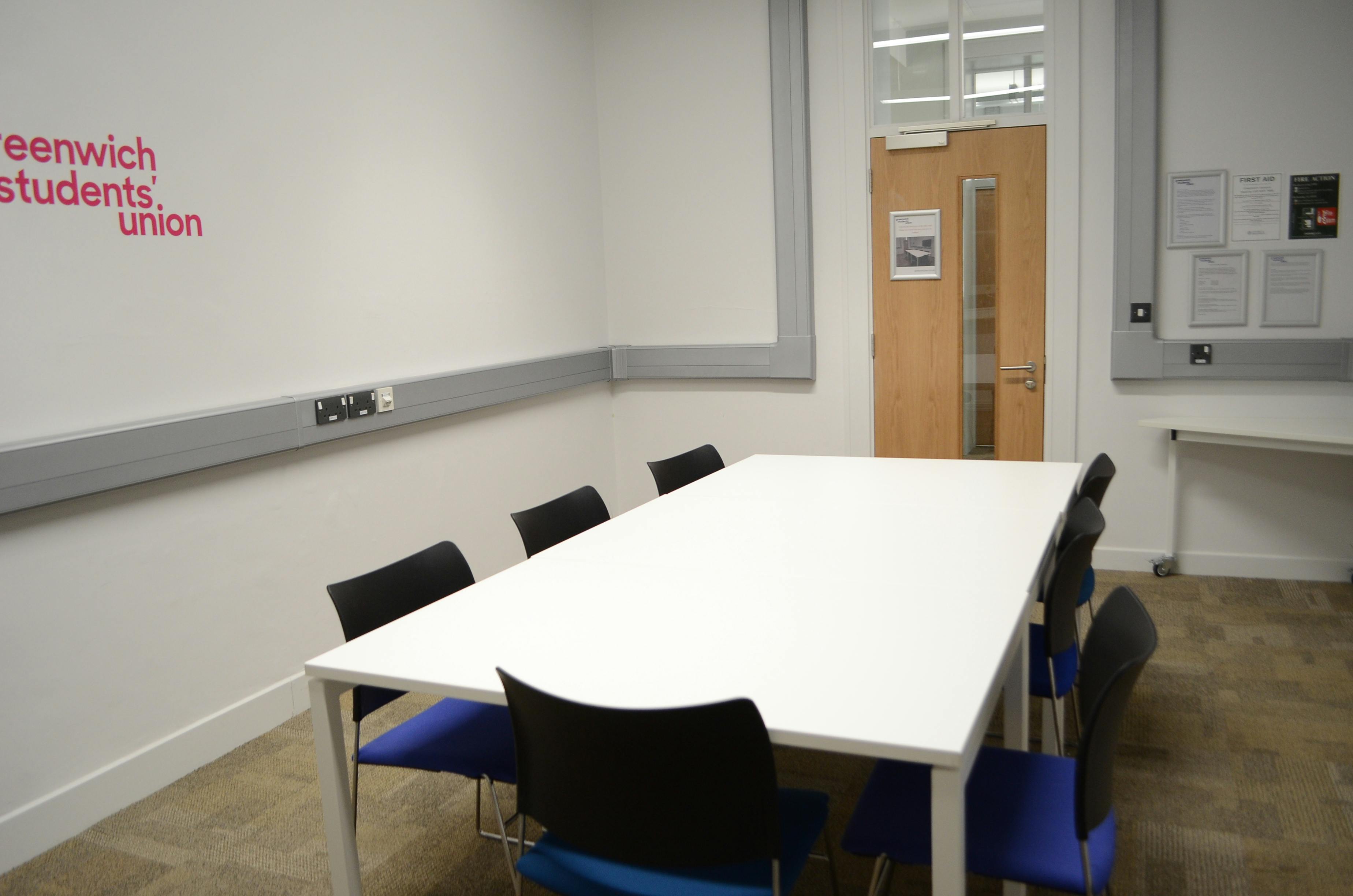 Small meeting room with white table and modern chairs for collaborative brainstorming sessions.