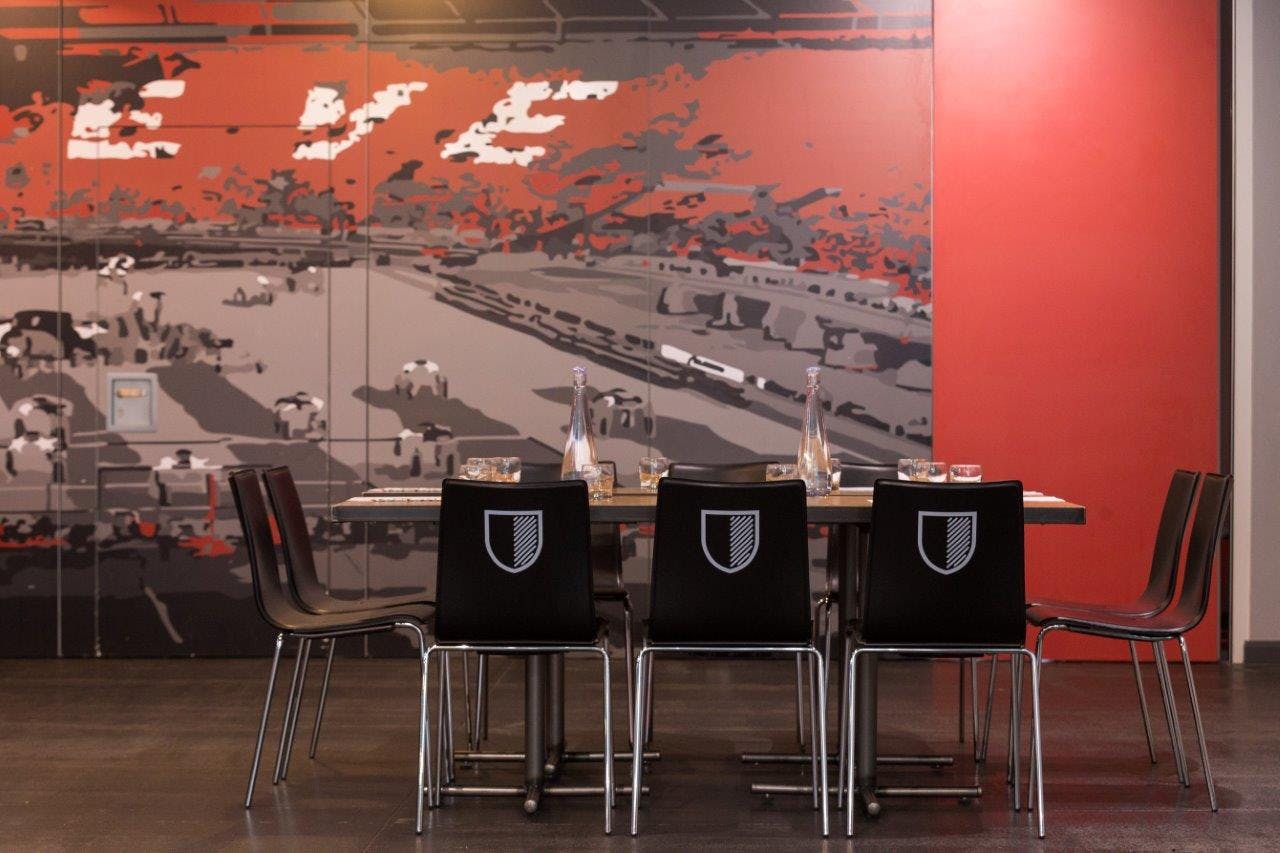 Old Trafford Supporters Club meeting space with logo chairs, ideal for team-building events.