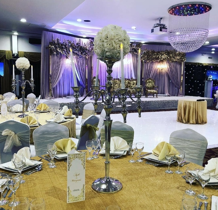 Elegant ballroom with floral stage, perfect for weddings and formal events.