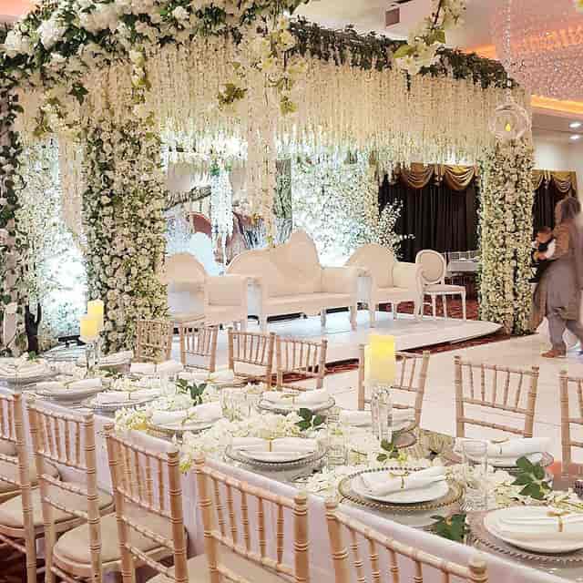 Elegant wedding venue with floral arrangements and white seating in The Willow's Ballroom.