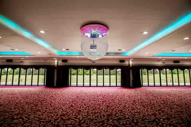 Elegant ballroom with chandelier, perfect for weddings and corporate events.