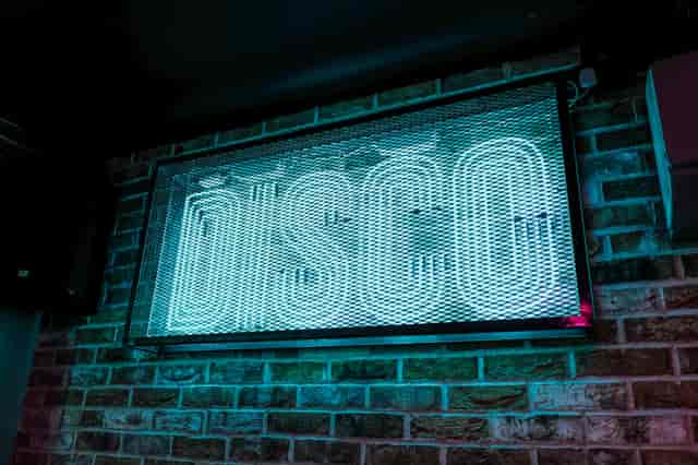 Vibrant neon "DISCO" sign in Simmons Function Room, perfect for lively parties and celebrations.