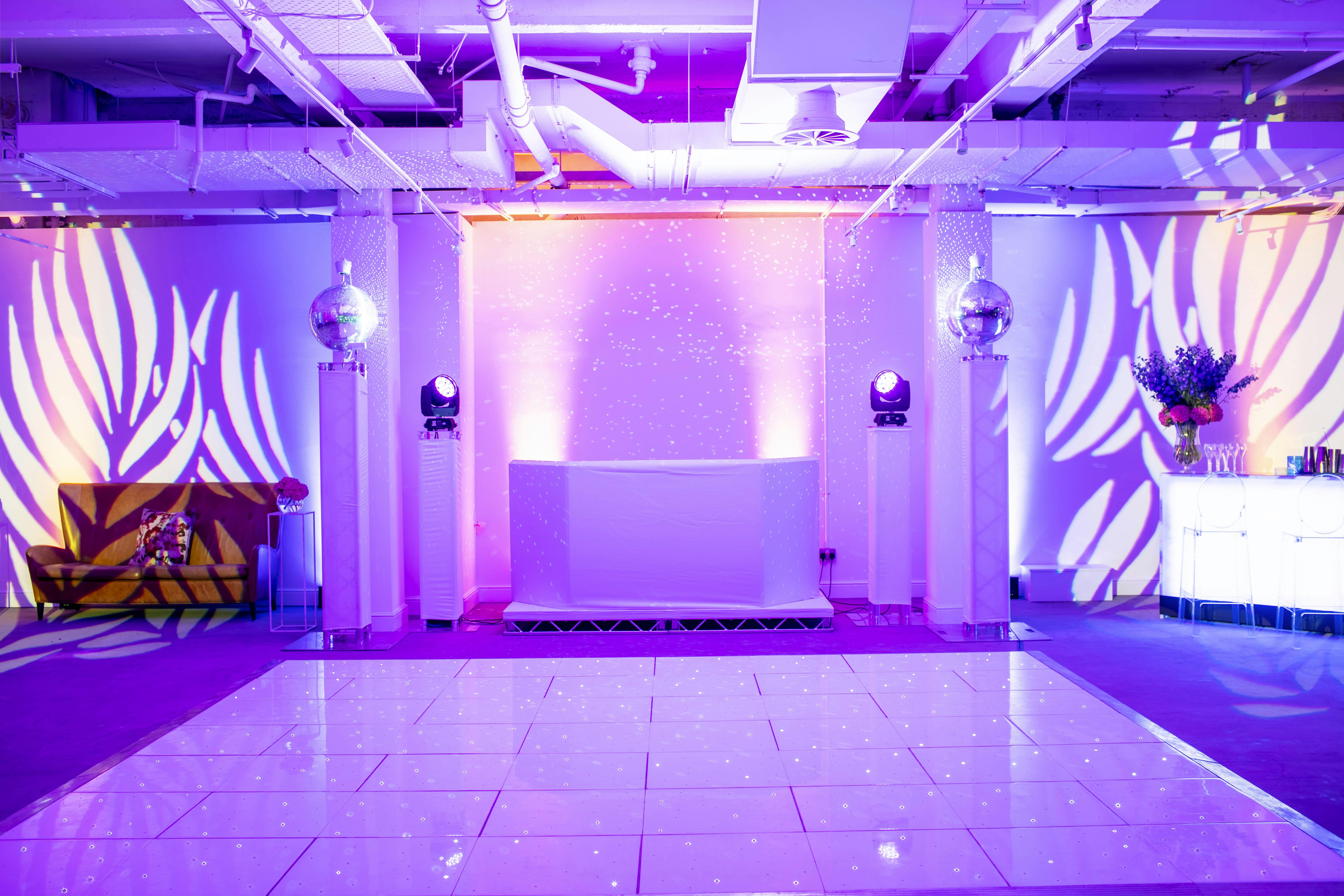 Stylish Campbell Room at Bluebird Chelsea with purple lighting for corporate events.