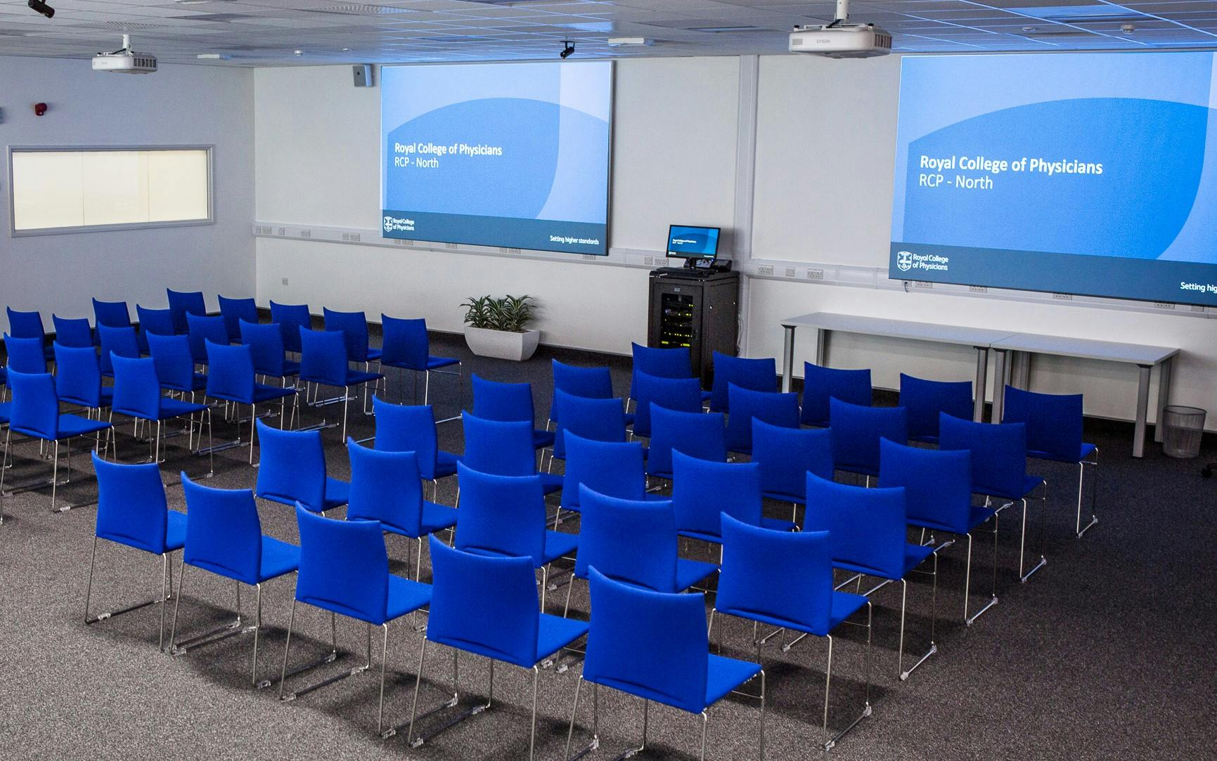 Manchester Room in RCP North with blue chairs, ideal for meetings and presentations.