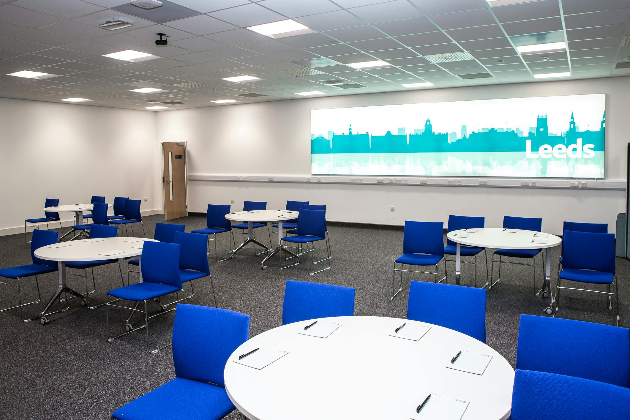 Modern Leeds Room in RCP North with circular tables, ideal for workshops and meetings.