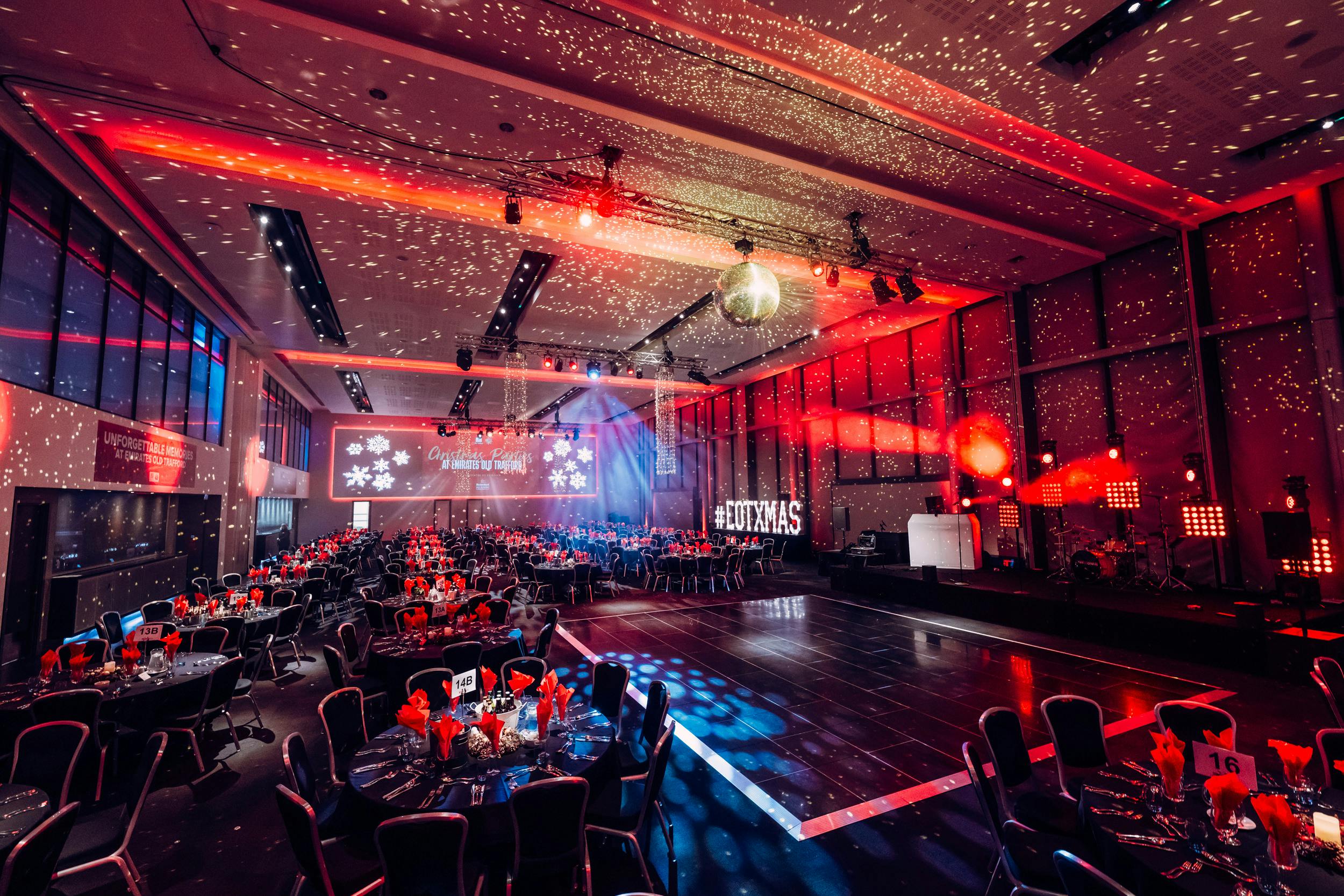 Vibrant gala event space at The Point, Emirates Old Trafford with elegant tables and stage.