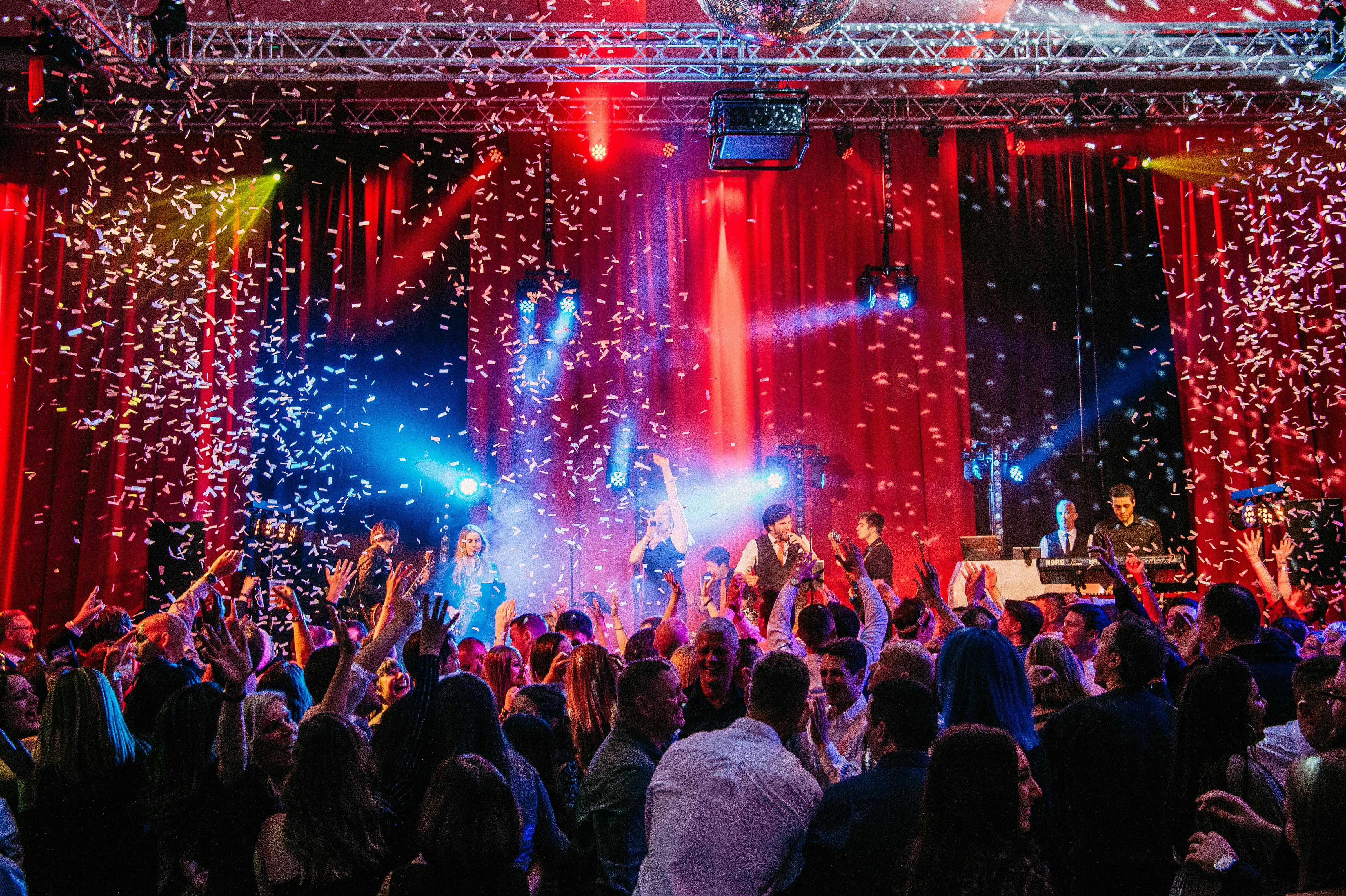 Vibrant crowd at The Point, Emirates Old Trafford, celebrating a gala event with confetti.