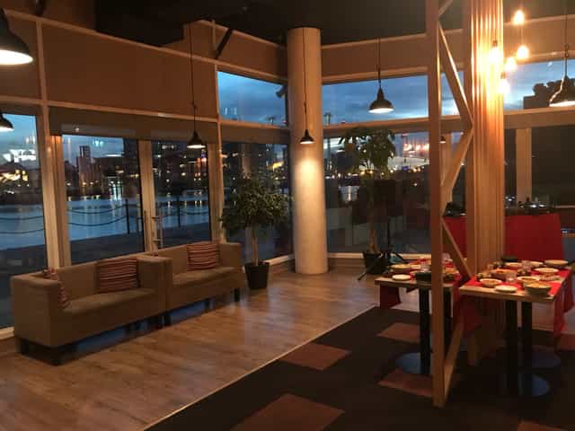 Stylish event space with large windows, ideal for networking and social gatherings.