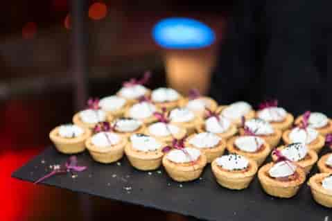 Elegant hors d'oeuvres on a black tray for upscale events and networking functions.