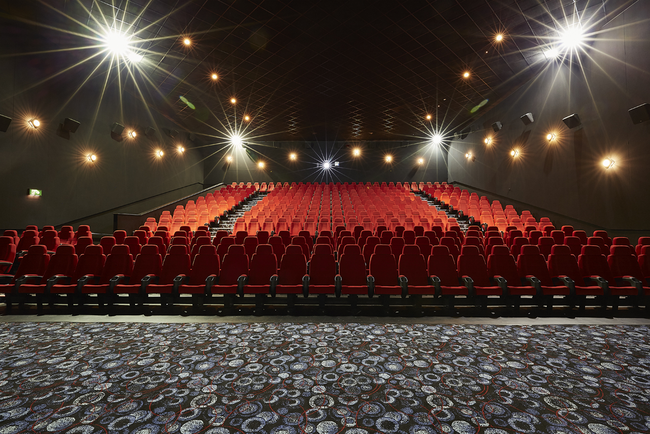 Large screen theater with red seating in Cineworld Birmingham for events and screenings. - Banner